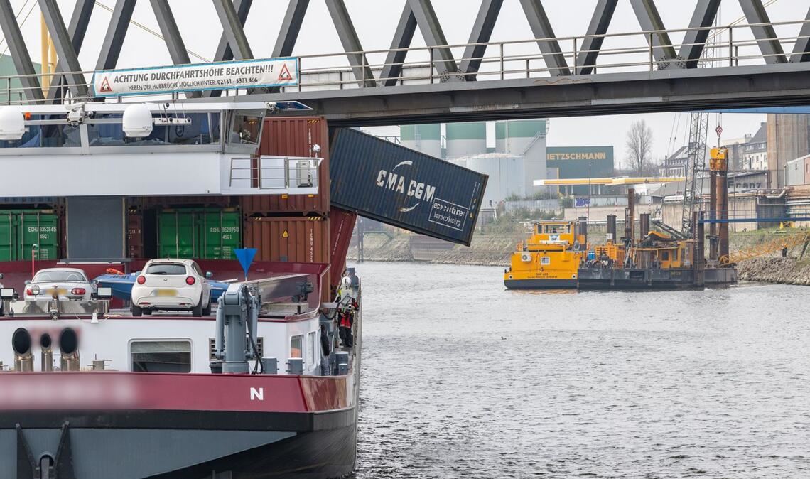 Ein Containerschiff liegt im Neusser Hafen. Das Schiff hat eine Brücke gerammt, mehrere Container fielen ins Wasser.