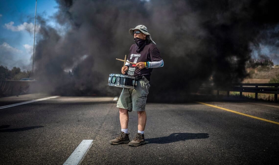 Ein Demonstrant trommelt bei einer Straßenblockade in Israel für die sofortige Freilassung aller von der Terrororganisation Hamas festgehaltenen Geiseln und das Ende des Krieges im Gazastreifen.