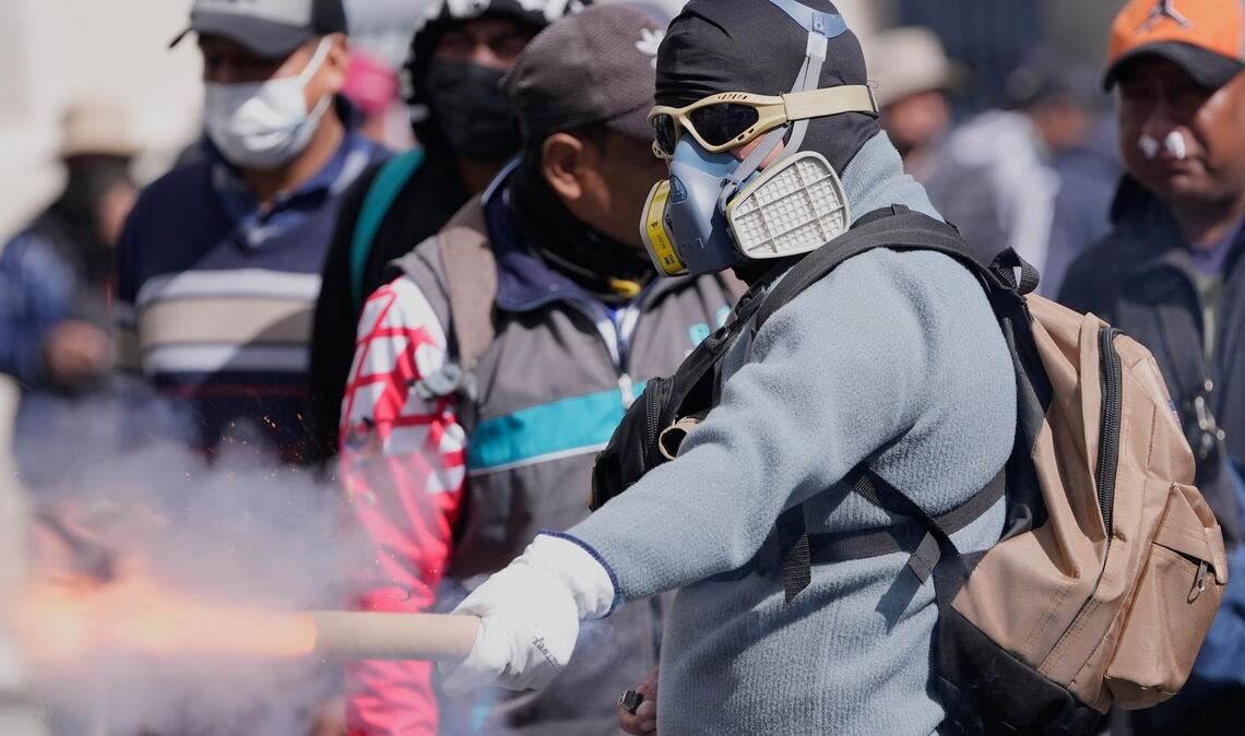 Ein Demonstrant wirft einen Feuerwerkskörper auf die Polizei.