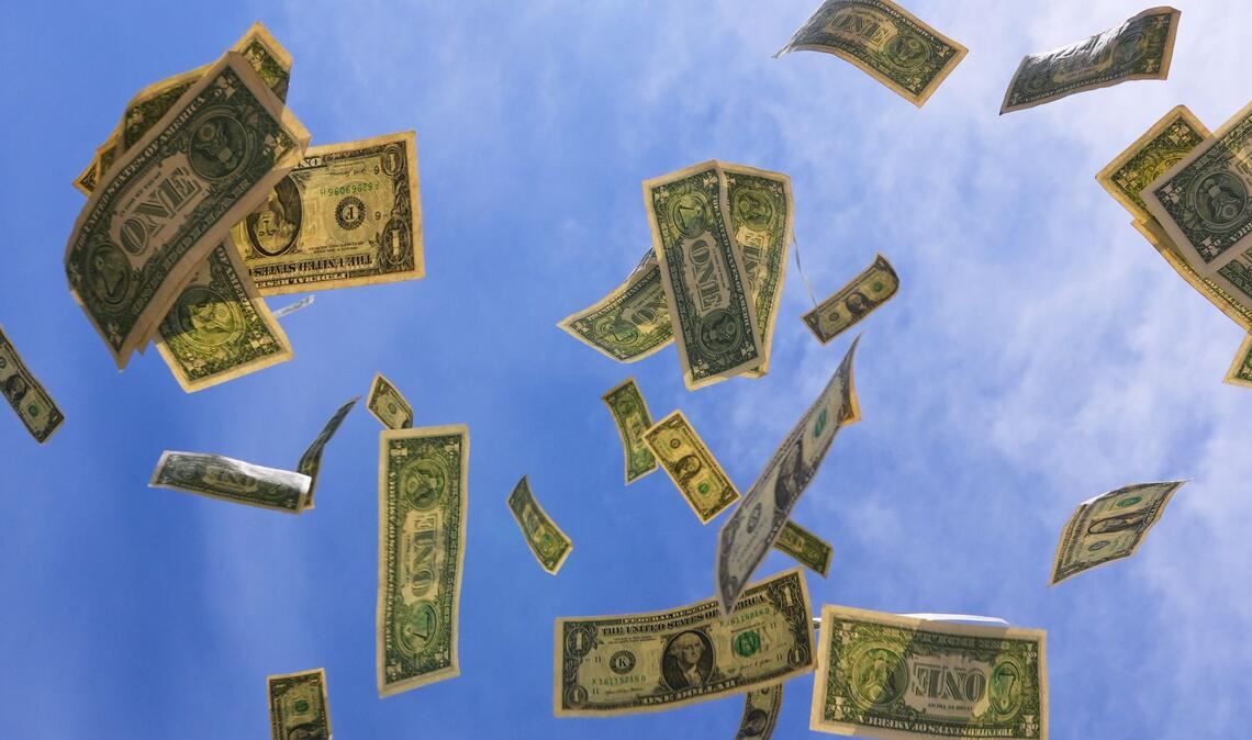 Ein-Dollar-Scheine aus den USA fallen mit dem Himmel im Hintegrund in Dallas.