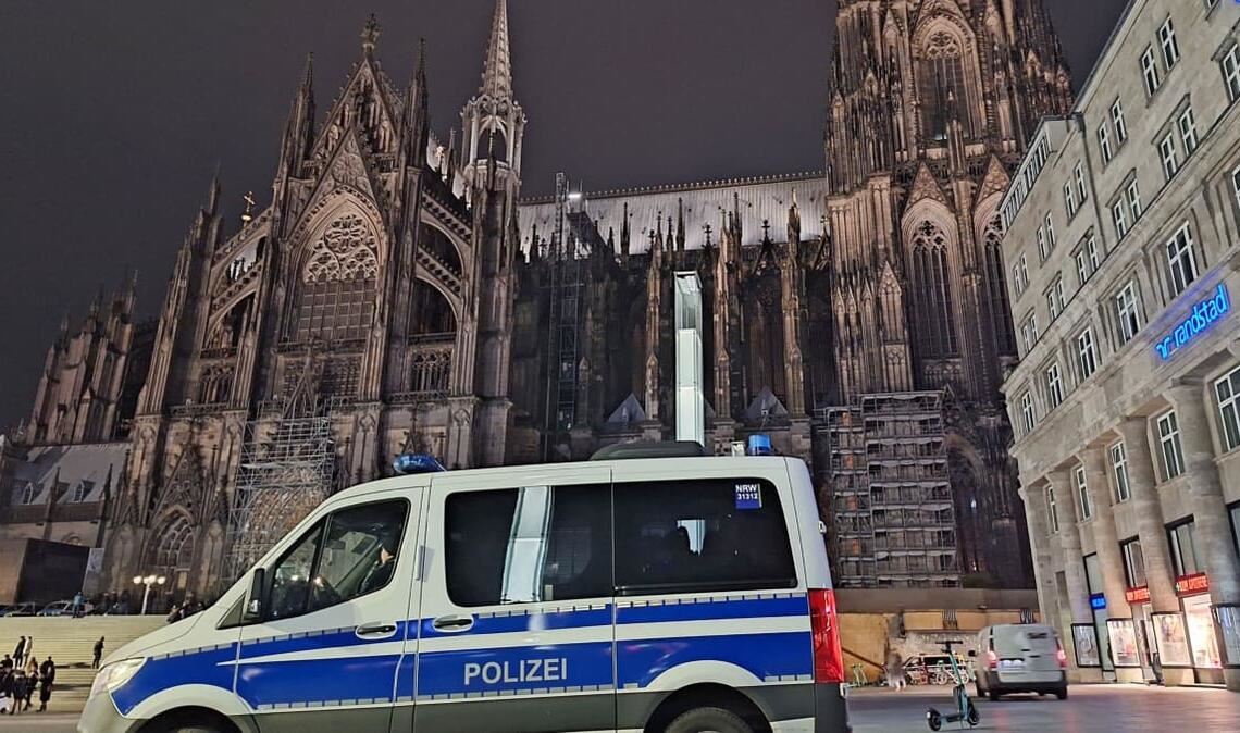 Ein Einsatzfahrzeug der Polizei steht vor dem Dom.