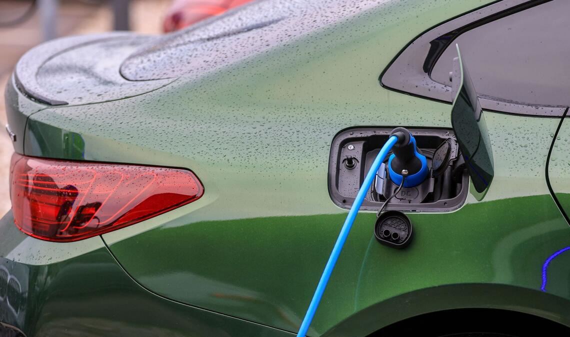 Ein Elektrofahrzeug von BMW lädt an einer Ladesäule.