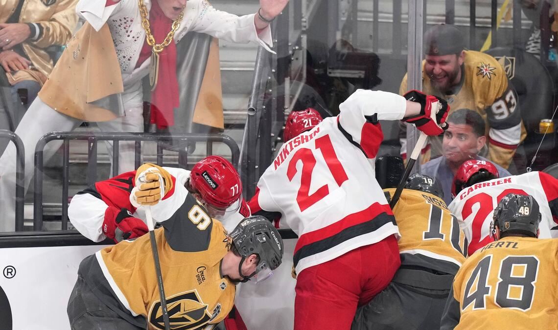 Ein Elvis-Imitator schlägt auf die Scheibe, während die Spieler um den Puck kämpfen.