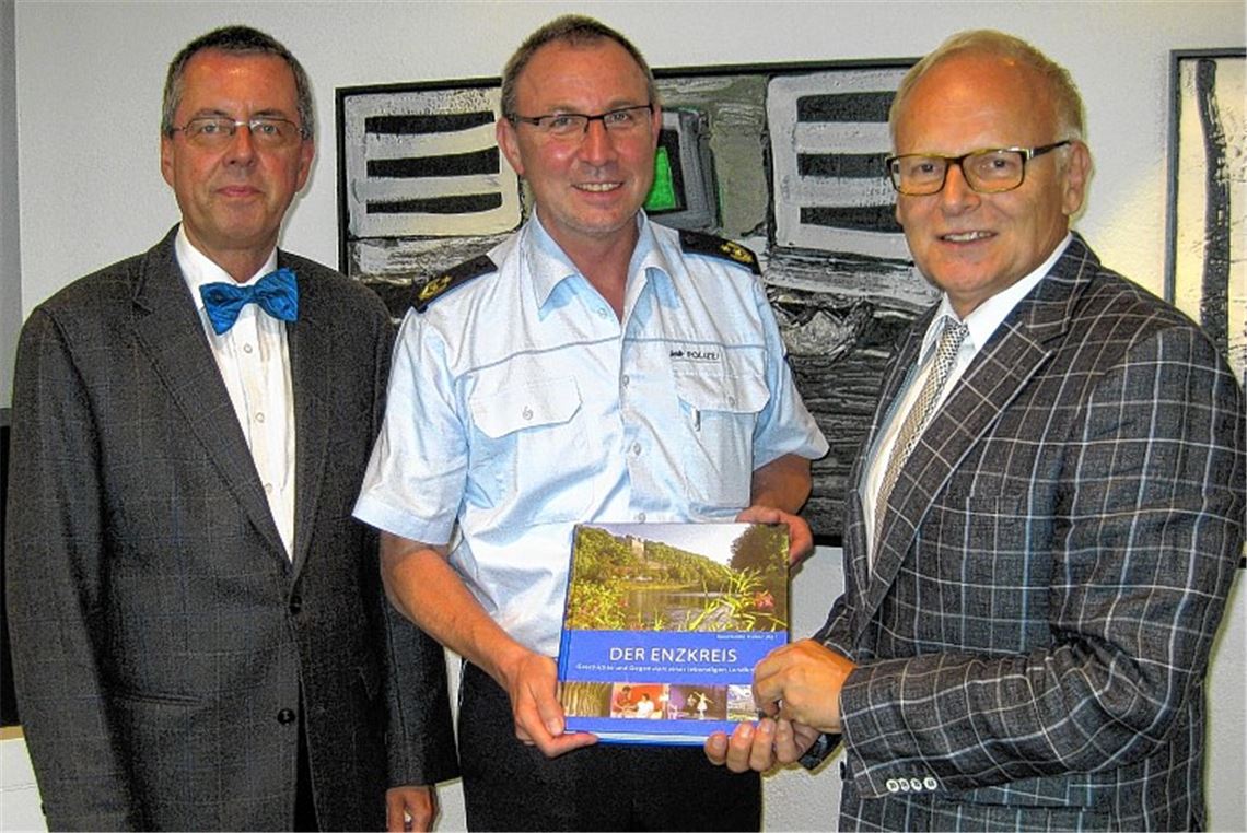Ein Enzkreis-Buch überreichen Landrat Karl Röckinger (re.) und sein Stellvertreter Wolfgang Herz (li.) dem neuen Karlsruher Polizeipräsidenten Günther Freisleben. Foto: privat