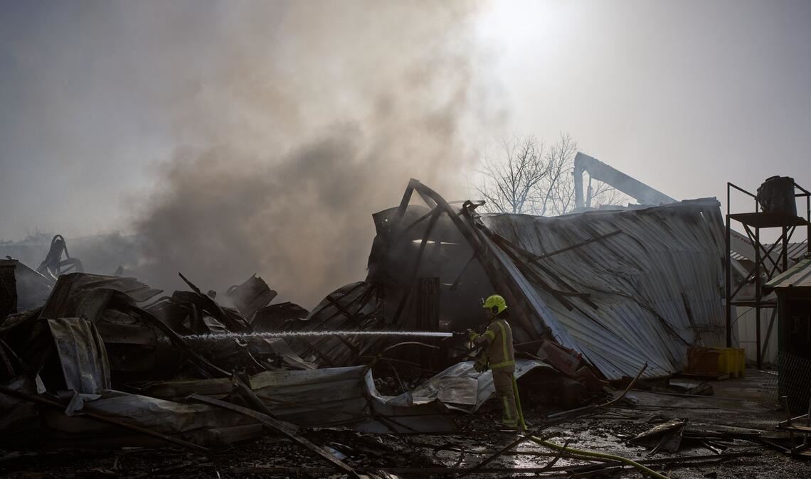 Ein Feuerwehrmann löscht in Zentralisrael ein Feuer an der Stelle, an der eine iranische Rakete eingeschlagen ist.