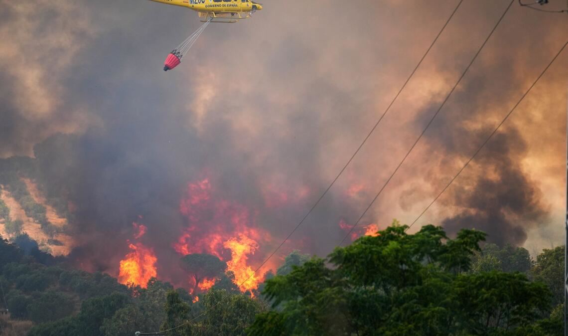 Ein Hubschrauber ist bei einem Waldbrand in Spanien am Odiel-Fluss in der Gemeinde Gibraleón im Einsatz.