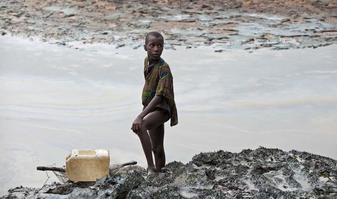 Ein Junge steht am Ufer eines ölverschmutzten Baches in der Nähe von Goi in Nigeria (Archivbild)