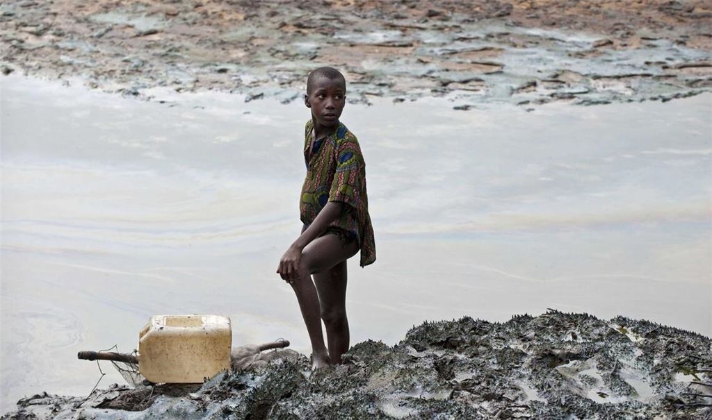 Ein Junge steht am Ufer eines ölverschmutzten Baches in der Nähe von Goi in Nigeria (Archivbild)