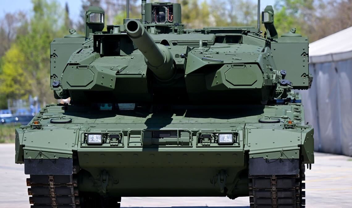 Ein Kampfpanzer Leopard 2 steht auf dem Werksgelände des Unternehmens KNDS vor einer Werkshalle (Archivfoto).