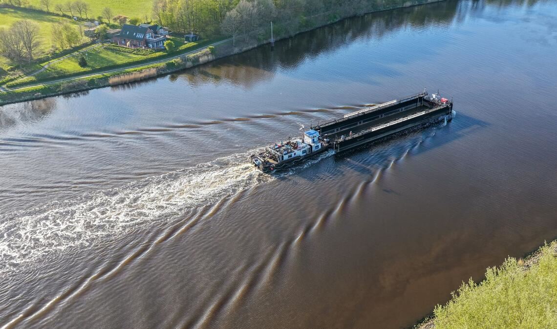 Ein Lastkahn, geschoben von dem Schubschiff "Hans" fährt auf dem Nord-Ostsee-Kanal bei Hohenhörn. Vor fast einem Monat ist der Buckelwal vor der Insel Poel bei Wismar gestrandet. Diese Woche soll Schiffstechnik den Abtransport des Tiers ermöglichen.