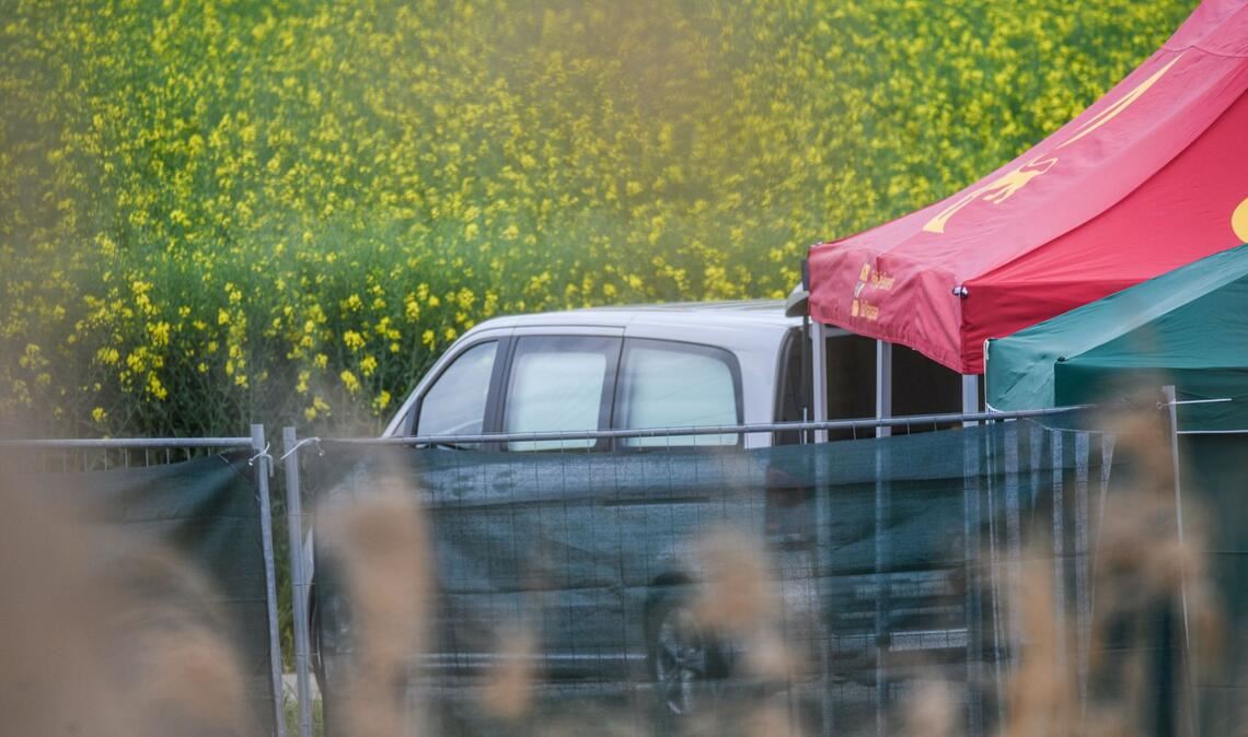 Ein Leichenwagen steht auf einem Feldweg in Baden-Württemberg, wo eine tote Frau in einem Auto entdeckt wurde.