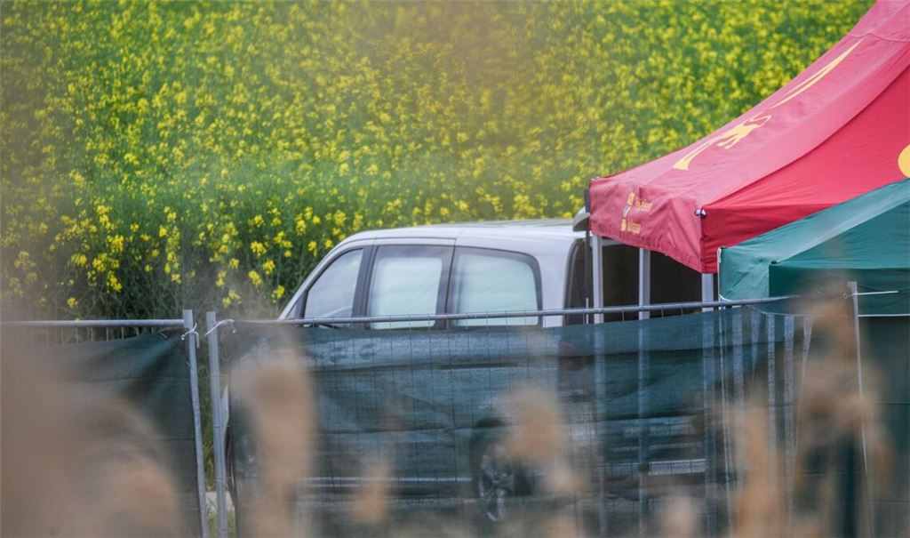 Ein Leichenwagen steht auf einem Feldweg in Baden-Württemberg, wo eine tote Frau in einem Auto entdeckt wurde.
