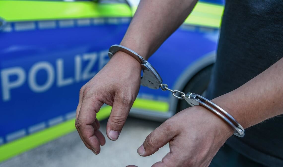 Ein Mann, dessen Hände mit Handschellen gefesselt sind. (Symbolfoto)