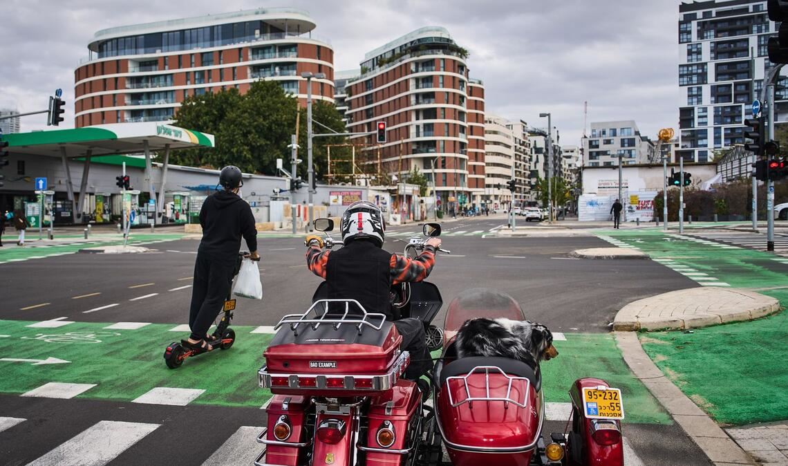Ein Mann fährt auf seinem Motorrad mit seinem Hund in Tel Aviv, Israel.