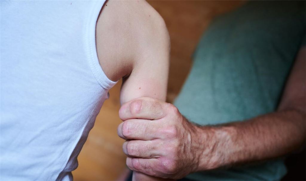 Ein Mann hält ein Kind fest am Arm (gestellte Szene). (Symbolbild)