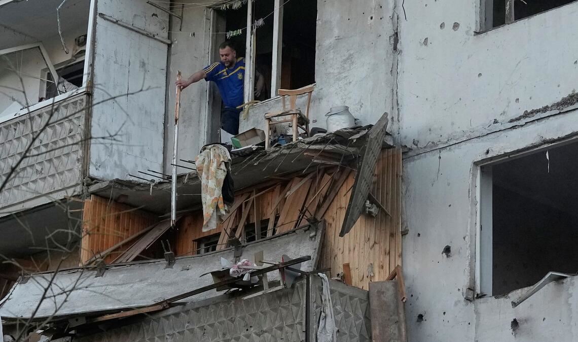 Ein Mann räumt in Kiew Trümmer an seinem Wohnhaus raus, das nach einem russischen Raketeneinschlag beschädigt wurde.