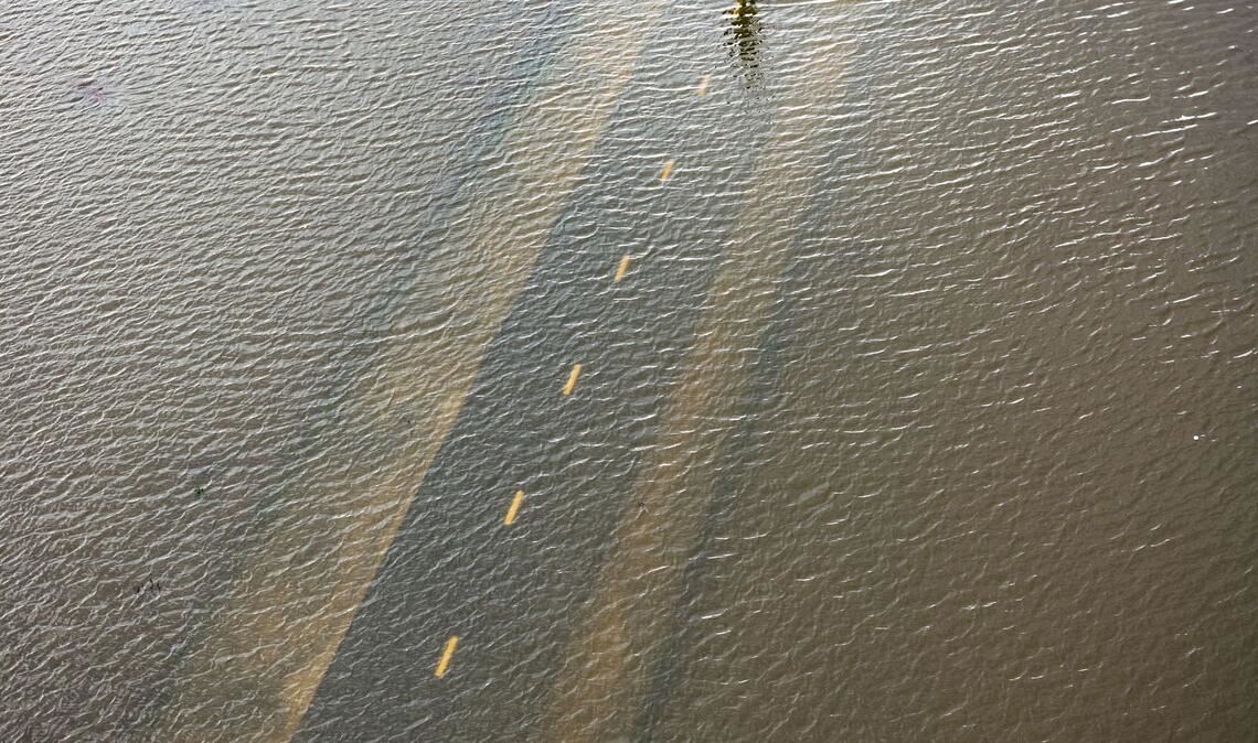 Ein Mensch geht auf einem überfluteten Weg während einer Springflut in Kalifornien.