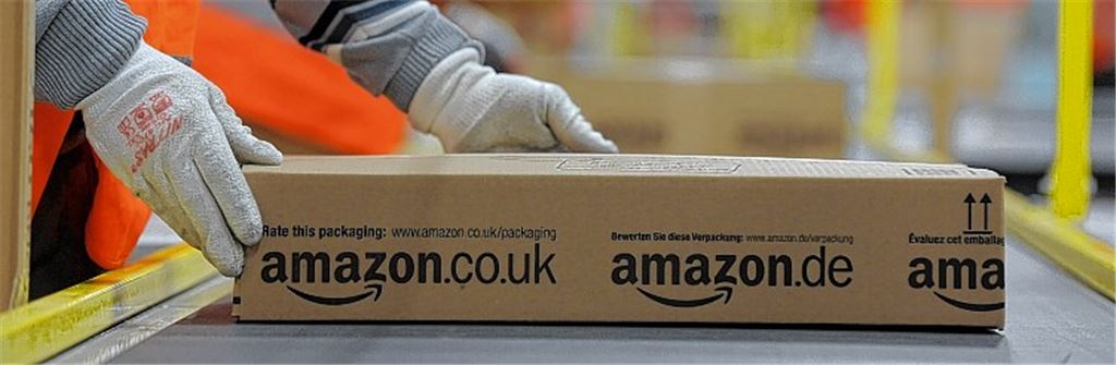 Ein Mitarbeiter der Versandabteilung des Amazon-Logistikzentrums in Pforzheim legt ein fertig verpacktes Paket auf ein Fließband. Der weltgrößte Online-Einzelhändler verdiente im Schlussquartal 2012 mit dem wichtigen Weihnachtsgeschäft unterm Strich 72 Millionen Euro und damit nur etwa halb so viel wie im Vorjahreszeitraum. Foto: Jan-Philipp Strobel/dpa