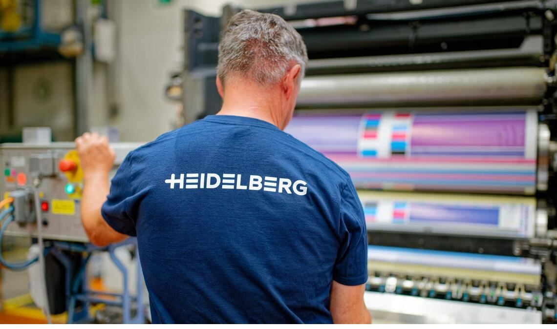 Ein Mitarbeiter steht in einer Produktionshalle von Heidelberger Druckmaschinen an einem Druckwerk.