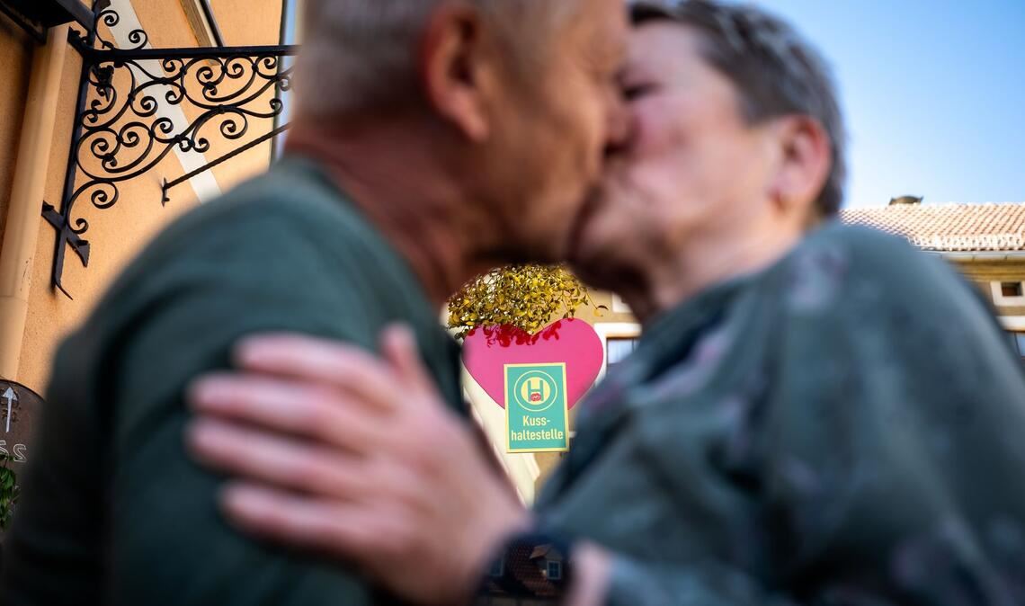 Ein Paar küsst sich an der Eisenberger "Kusshaltestelle".