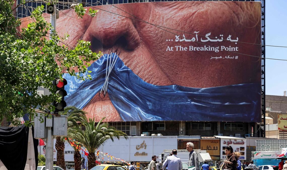 Ein Plakat in Teheran – US-Präsident Trump mit einem Stoffstück in der Form der Straße von Hormus vor dem zugenähten Mund