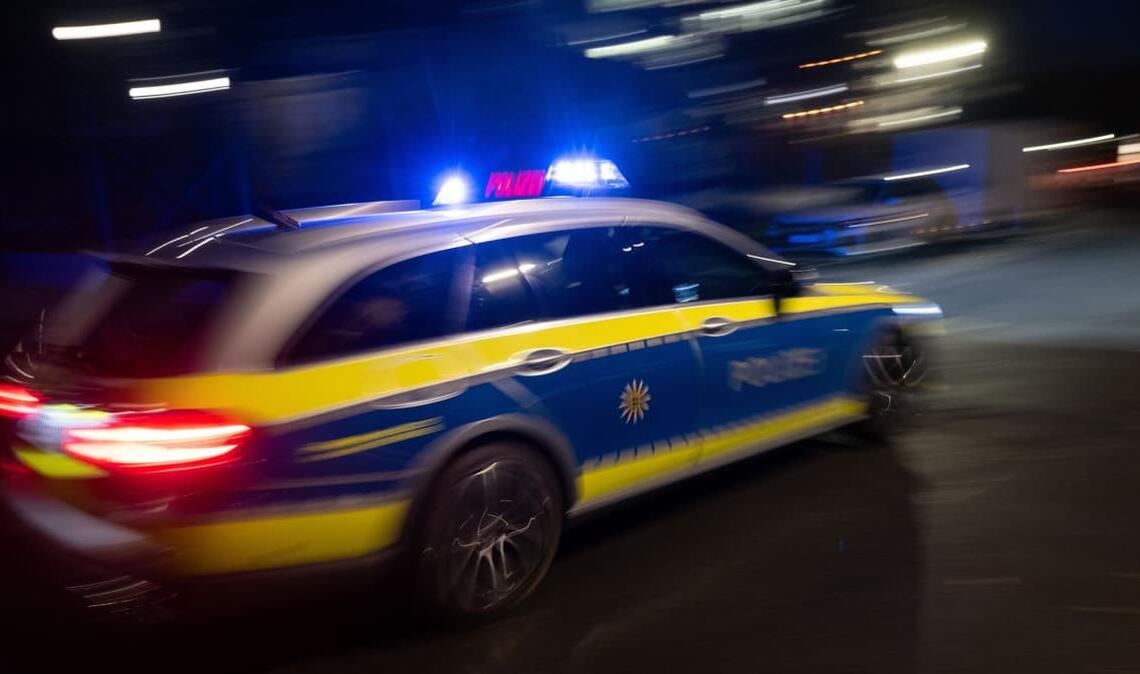 Ein Polizeifahrzeug fährt im Rahmen eines Fototermins mit Blaulicht an einem Gebäude vorbei (gestellte Szene, Langzeitblichtung mit Wischeffekt). (zu dpa: «Blutüberströmter Mann stoppt Auto nach Messerattacke»)