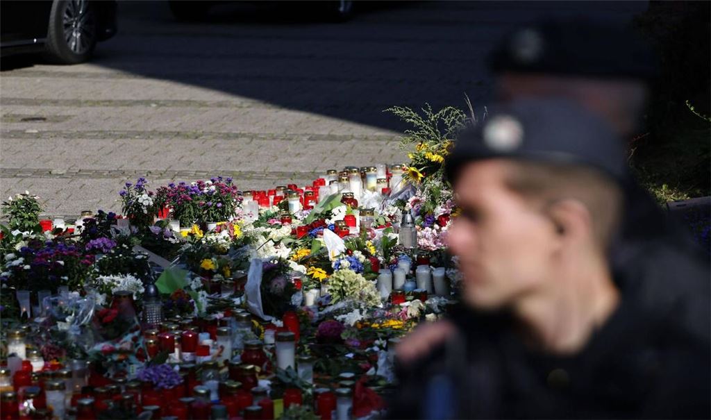 Ein Polizist steht vor einem Blumen, die Menschen abgelegt haben, um der drei Todesopfer eines Anschlags aus dem August 2024 zu gedenken. (Archivbild)