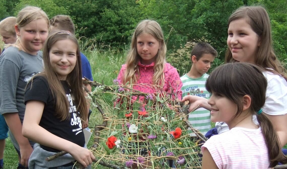 Naturpädagogik für Kinder wird wieder angeboten Ein Praxisbeispiel: Beim Knüpfen eines Blumenteppichs gibt es viel zu lernen. Foto: Enzkreis