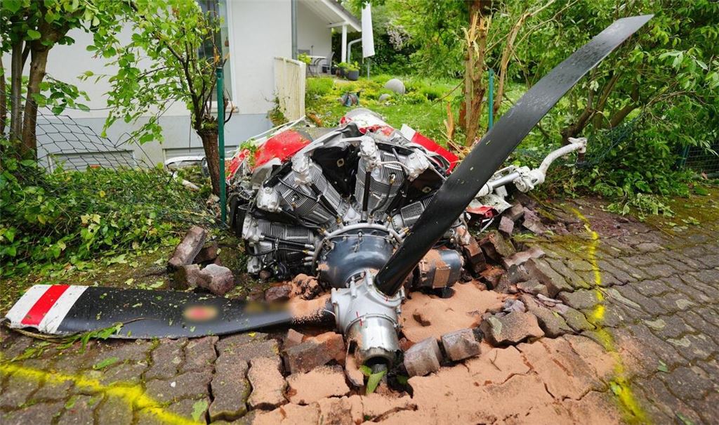 Ein Propeller der Maschine liegt vor einem Wohnhaus.
