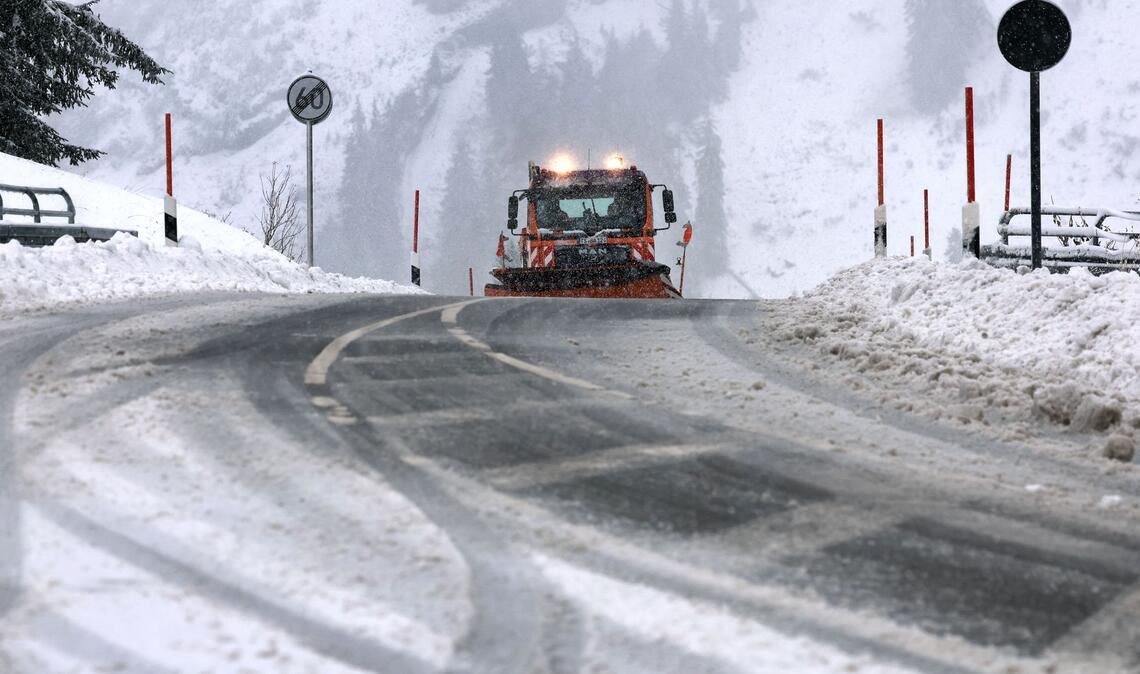 Ein Räumfahrzeug des Winterdienstes fährt auf dem Riedbergpass im Schneetreiben.