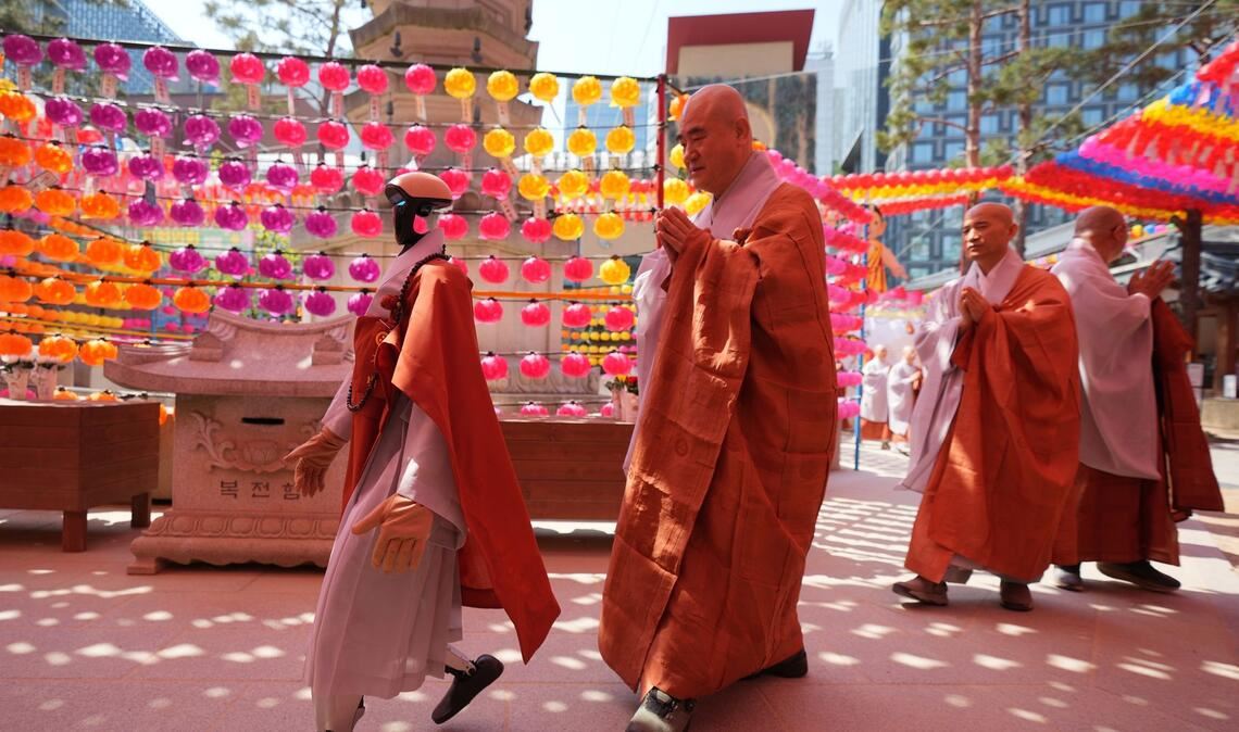 Ein Roboter und buddhistische Mönche umrunden zusammen eine Pagode während einer Zeremonie vor dem Geburtstag Buddhas im koreanischen Seoul.