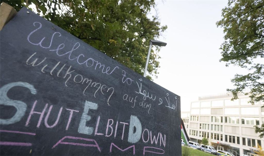 Ein Schild mit der Aufschrift «Willkommen auf dem ShutElbitDown Camp!» steht auf einem Protestcamp vor einem Bürogebäude (Archivbild).