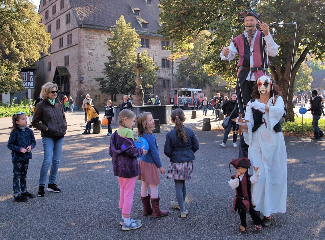 Ein Stelzenmann und eine Puppenspielerin tummeln sich zur Freude der Besucher auf dem Klosterplatz. Fotos: Filitz