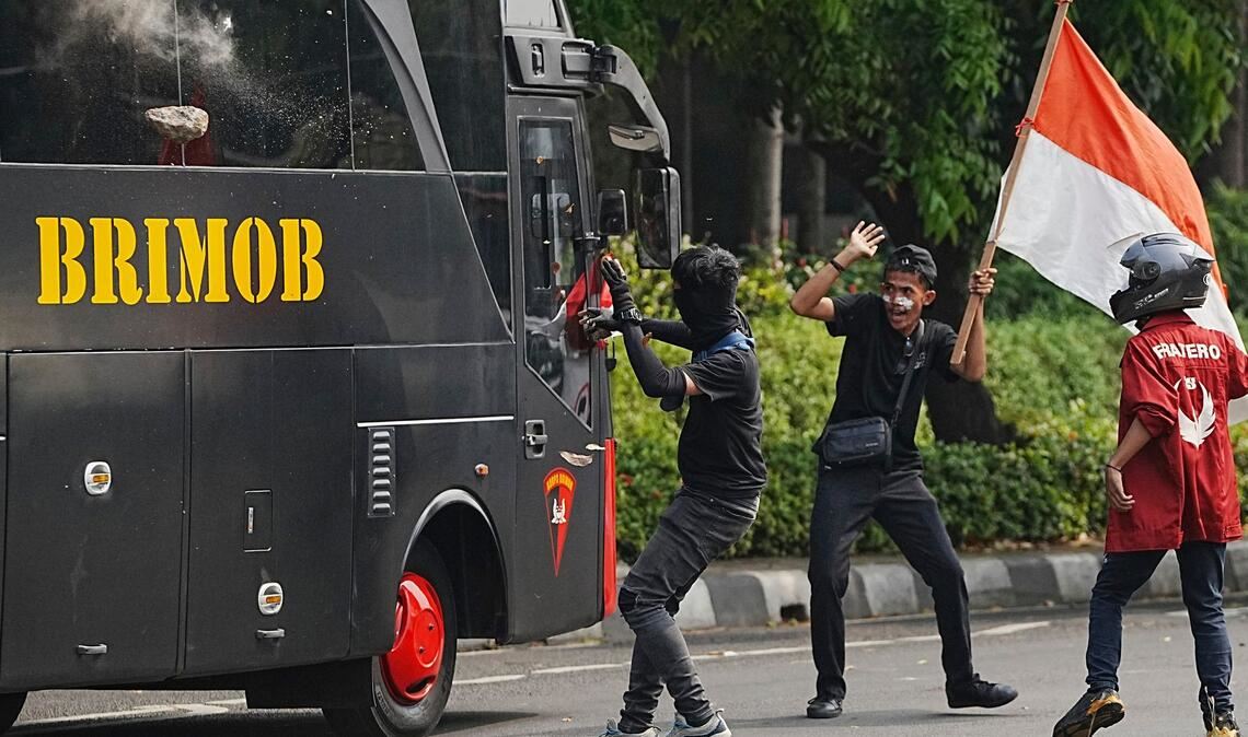 Ein Student wirft einen Stein auf ein Polizeifahrzeug bei gewalttätigen Protesten gegen üppigen Zulagen für Parlamentsmitglieder in Indonesien.