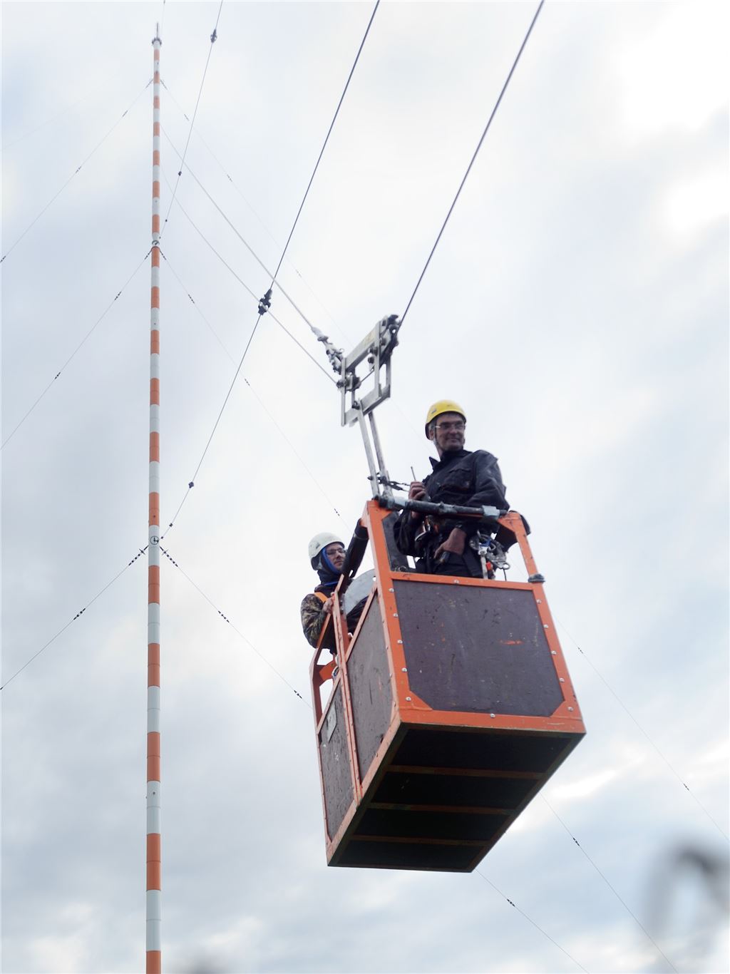 Ein Team von Spezialisten arbeitet vermutlich noch bis Freitag an den Halteseilen des Sendemasts. In einem Korb fahren sie an den Stahltrossen auf und ab. Foto: Fotomoment
