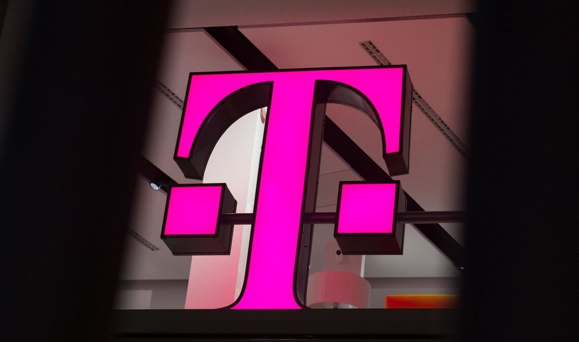 Ein Telekom-Logo strahlt in Magenta - für den Konzern sind die Behördenpläne eine gute Nachricht.
