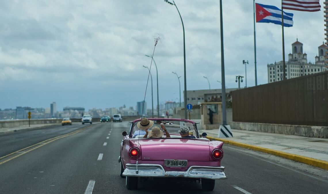 Ein US-Oldtimer transportiert Touristen an der US-Botschaft in Havanna vorbei.