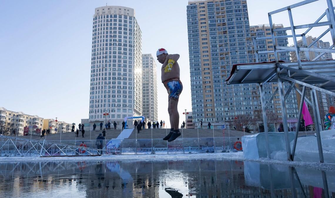 Ein Winterschwimmer springt in Harbin in der chinesischen Provinz Heilongjiang ins eiskalte Wasser.