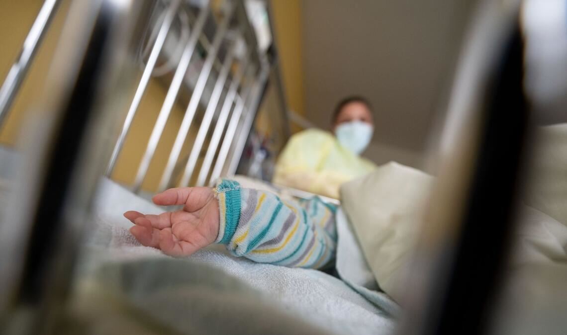 Ein am Respiratorischen Synzytial-Virus (RS-Virus oder RSV) erkrankter kleiner Patient liegt auf einer Kinderstation eines Klinkums in einem Krankenbett.