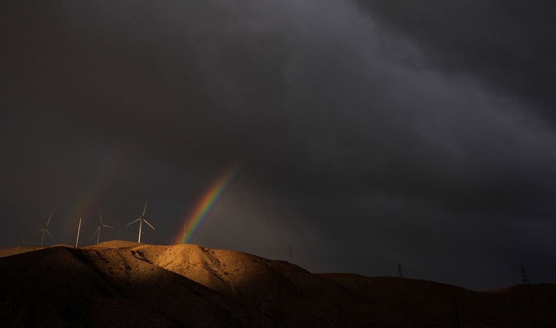 Ein doppelter Regenbogen erscheint hinter Windturbinen unter Gewitterwolken in der Nähe von Cathedral City in Kalifornien.