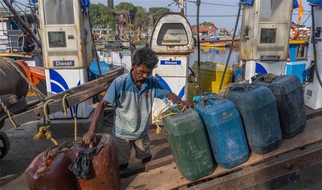 Ein indischer Arbeiter ordnet leere Treibstoffkanister auf seinem Handkarren im Hafen von Mumbai.