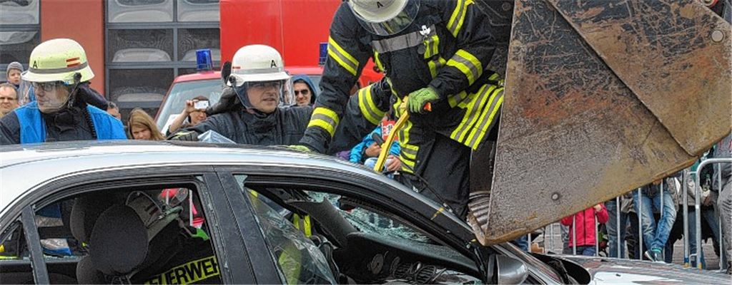 Einblick in die Arbeitsabläufe: Nach einem simulierten Unfall zwischen einem Auto und einem Baufahrzeug retten die Feuerwehrleute eine eingeklemmte Person.