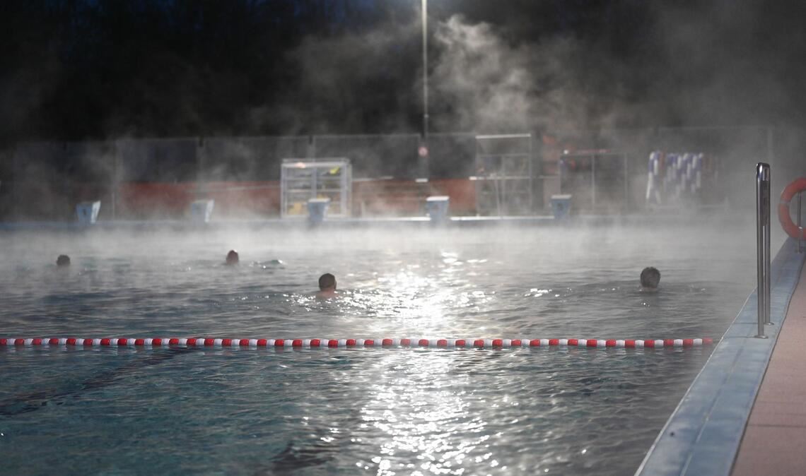 Eindlich geht's los -  Frühschwimmer sind schon vor Sonnenaufgang im Wasser des Friesenbads in Weener.