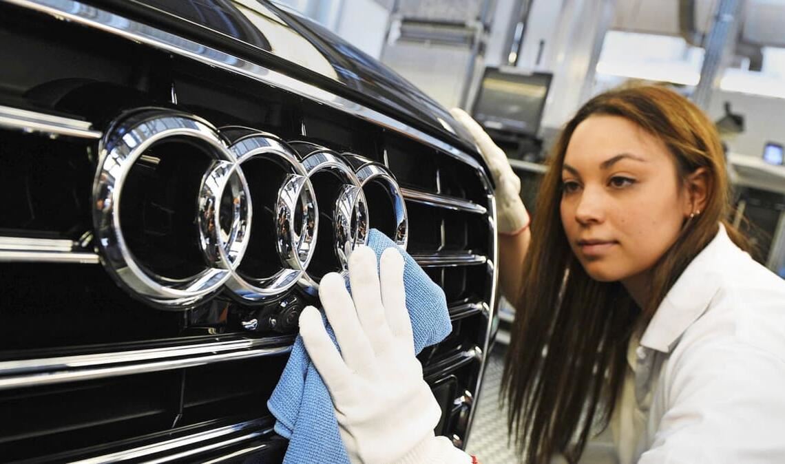 Eine Audi-Mitarbeiterin poliert in Neckarsulm die Audi-Ringe an einer A8-Limousine. Die Zukunft des Werks ist gefärhdet.