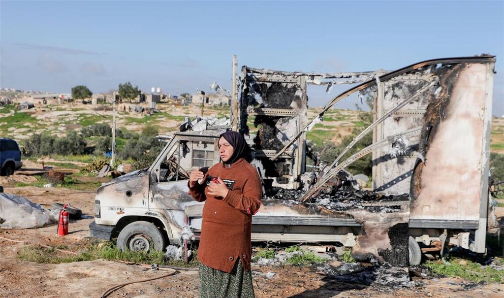 Eine Bewohnerin steht neben einem ausgebrannten Fahrzeug im Dorf Susya bei Hebron im besetzten Westjordanland. Israelische Siedler sollen Ende Februar dort Zelte und Autos angezündet haben.
