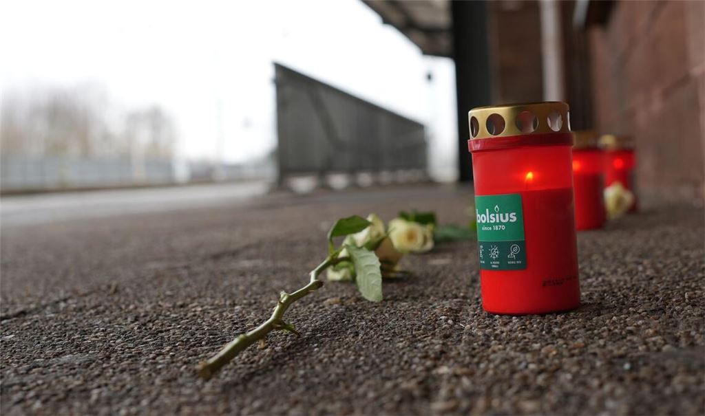 Eine Blume und Kerzen liegen am Bahnsteig nach dem Tod eines Zugbegleiters.