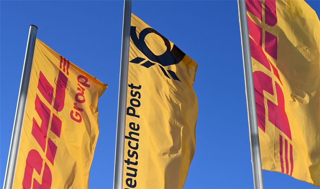 Eine Deutsche-Post-Fahne an der Konzernzentrale, umrahmt von DHL-Fahnen.