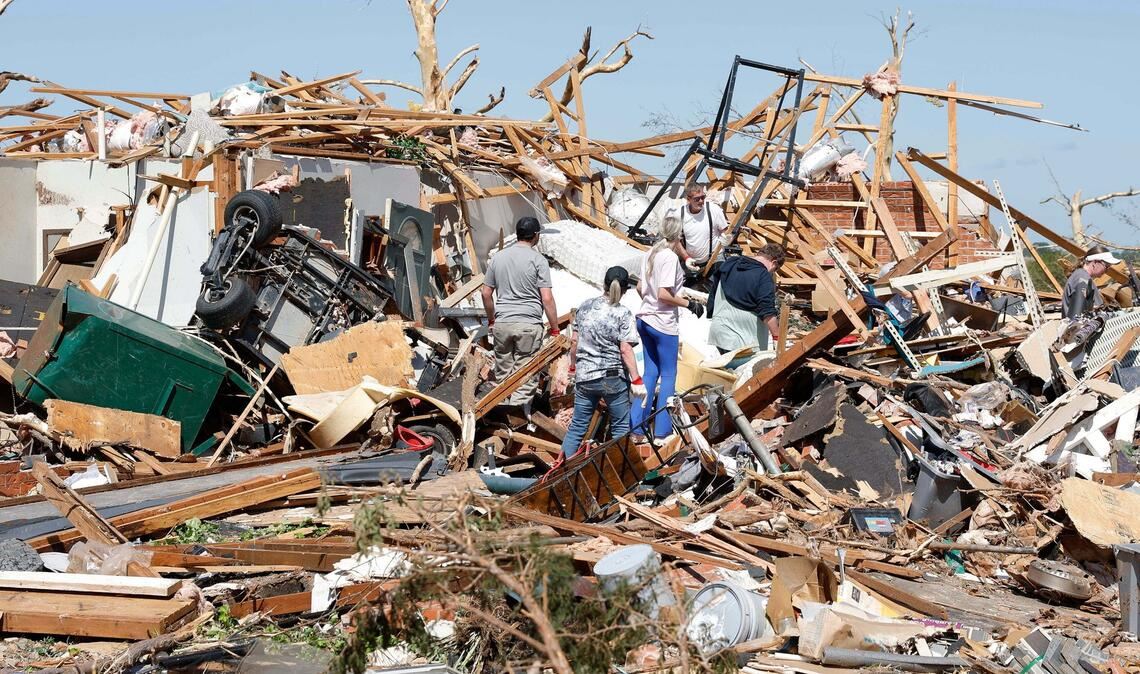 Eine Familie blickt nach einem Tornado durch die Trümmer ihres Hauses im Stadtteil Grayridge in Oklahoma.