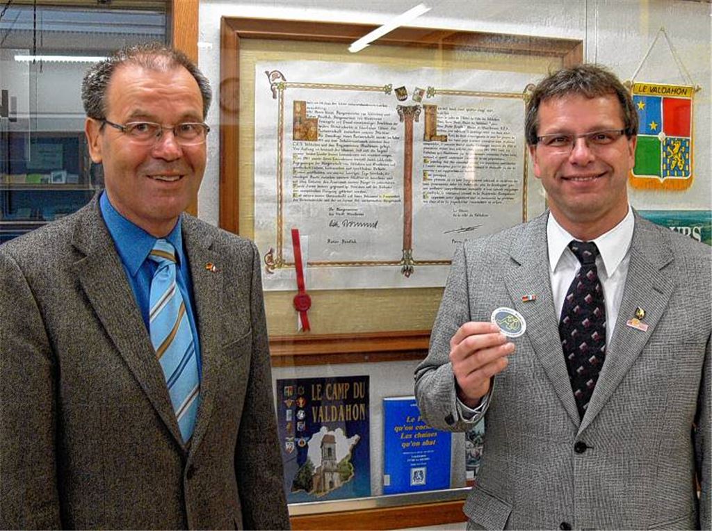 Eine Fotoausstellung berichtet von der Vergangenheit, das Partnerschaftskomitee und die Städte arbeiten an einer lebendigen Zukunft. Roland Evers, der Präsident des Partnerschaftskomitees (li.), und Bürgermeister Andreas Felchle stehen vor der Partnerschaftsurkunde aus dem Jahr 1987 und freuen sich auf die weiteren Aktivitäten im Jubiläumsjahr. Sie waren mit dabei (rechtes Bild): Willi Herzog, Ute Trick, Gabi Stuck-Herzog und Lothar Trick erinnern sich bei der Ausstellungseröffnung an gemeinsame Erlebnisse mit ihren französischen Freunden aus Valdahon.