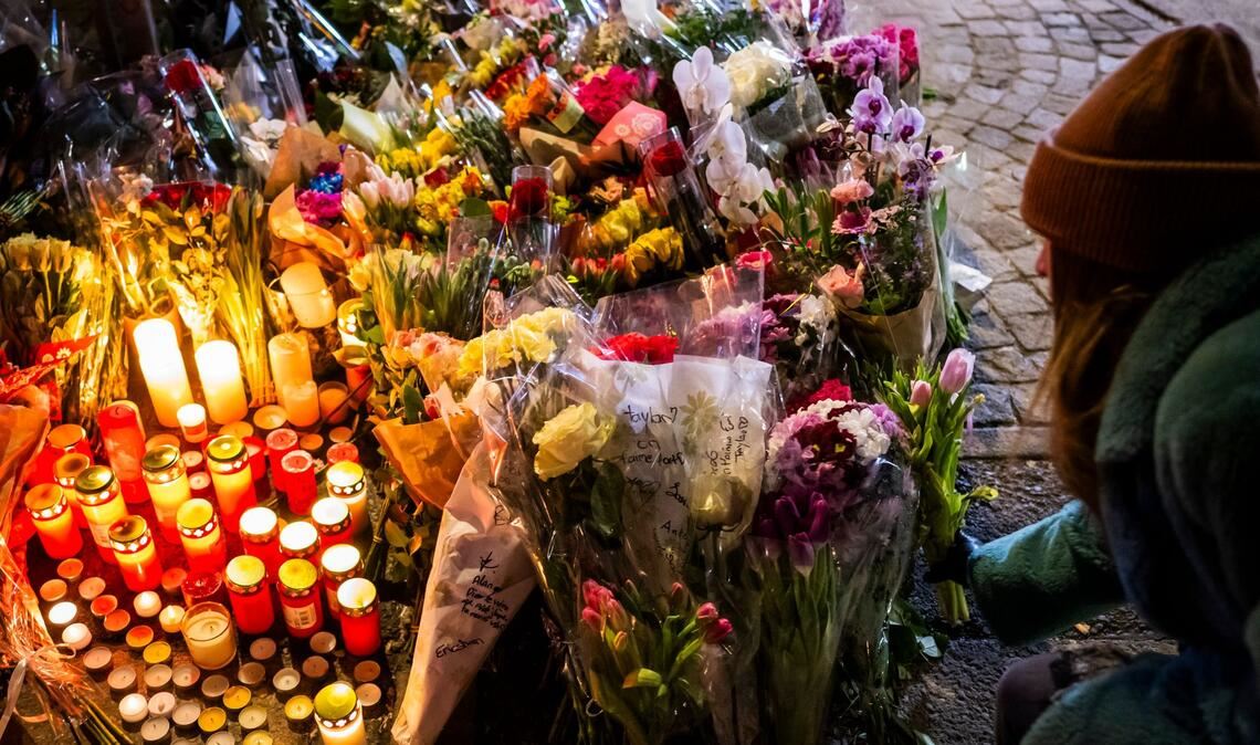 Eine Frau legt Blumen in der Nähe des Ortes nieder, an dem während der Neujahrsfeierlichkeiten in der Bar und Lounge "Le Constellation" in Crans-Montana ein Brand ausgebrochen war, der Todesopfer und Verletzte forderte.